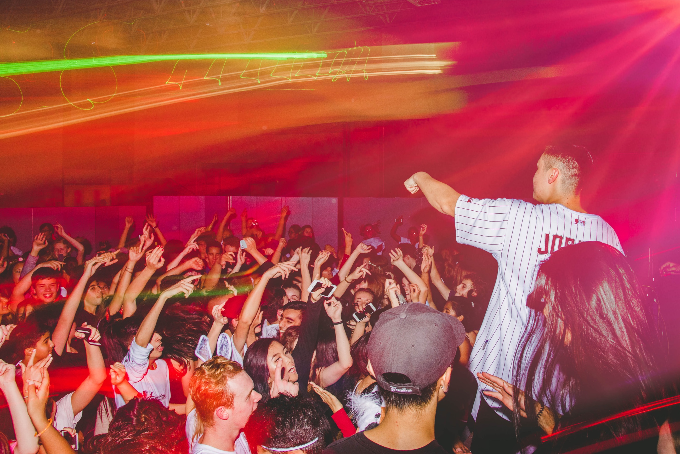 A performer energizing a crowd under red stage lights