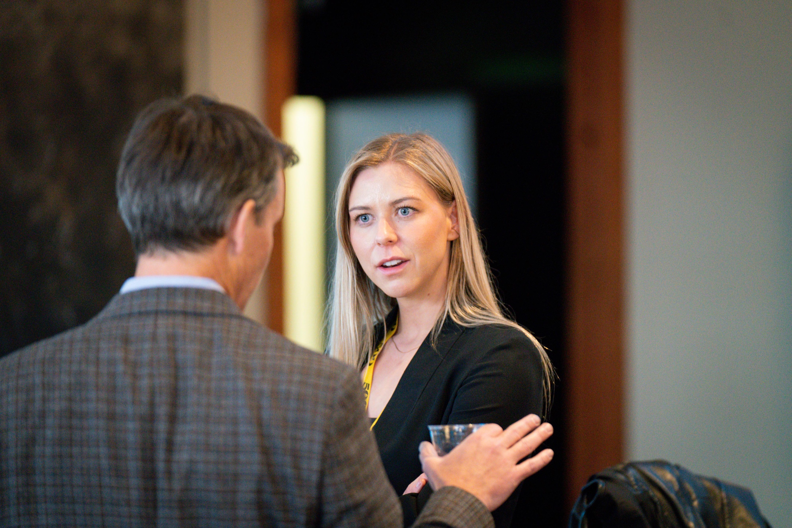 Two guests in conversation at a professional gathering