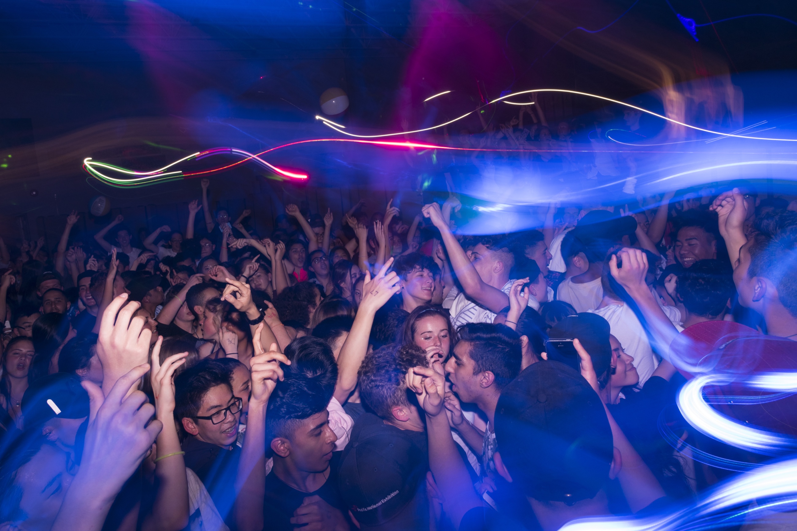 A packed dance floor traced with colourful light