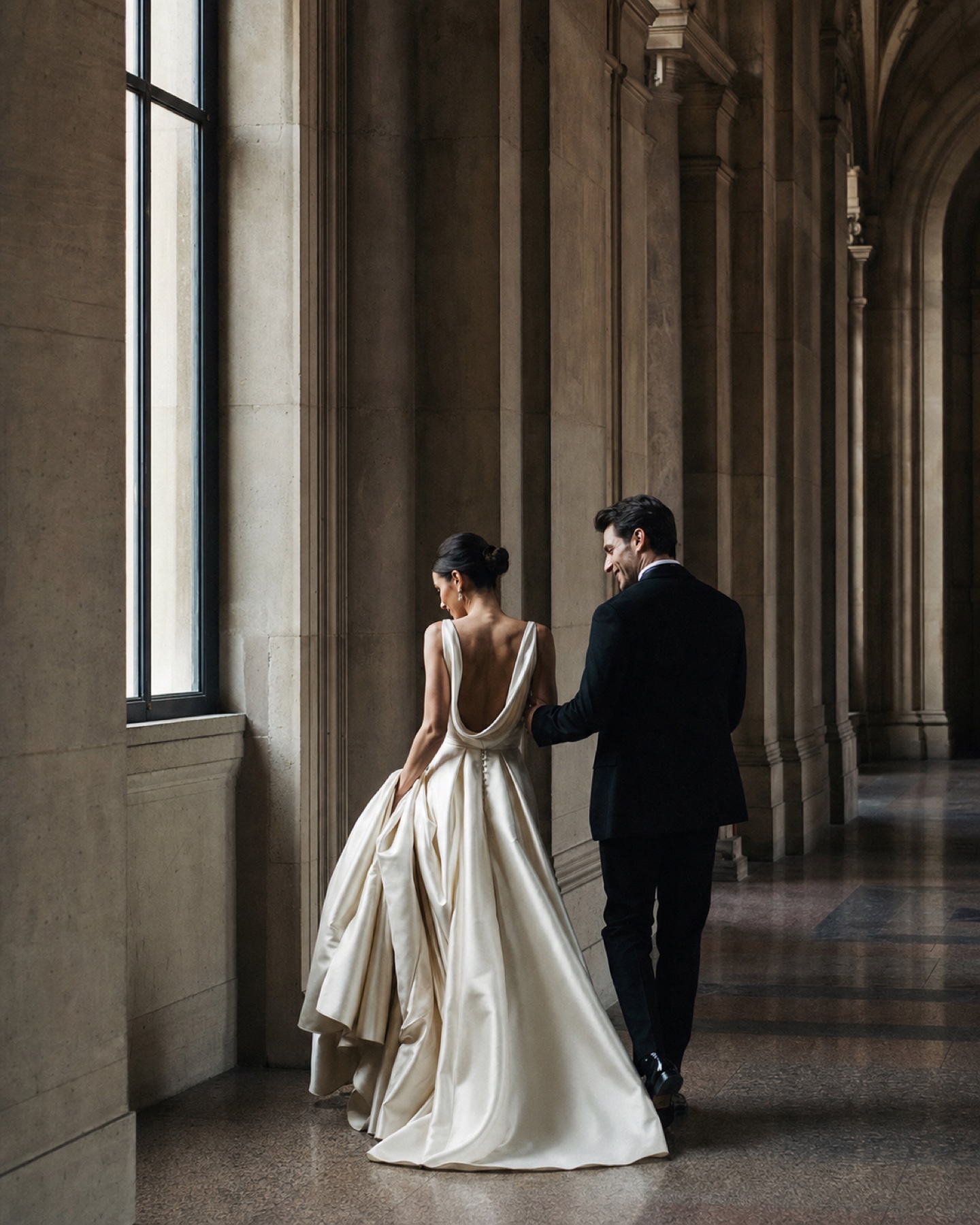 A couple walking through an architectural corridor
